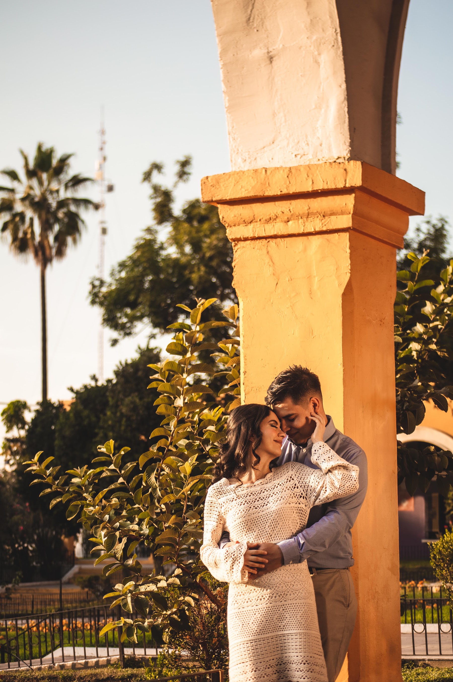 Retrato del novio entre columnas de tonos cálidos en Tlaquepaque.