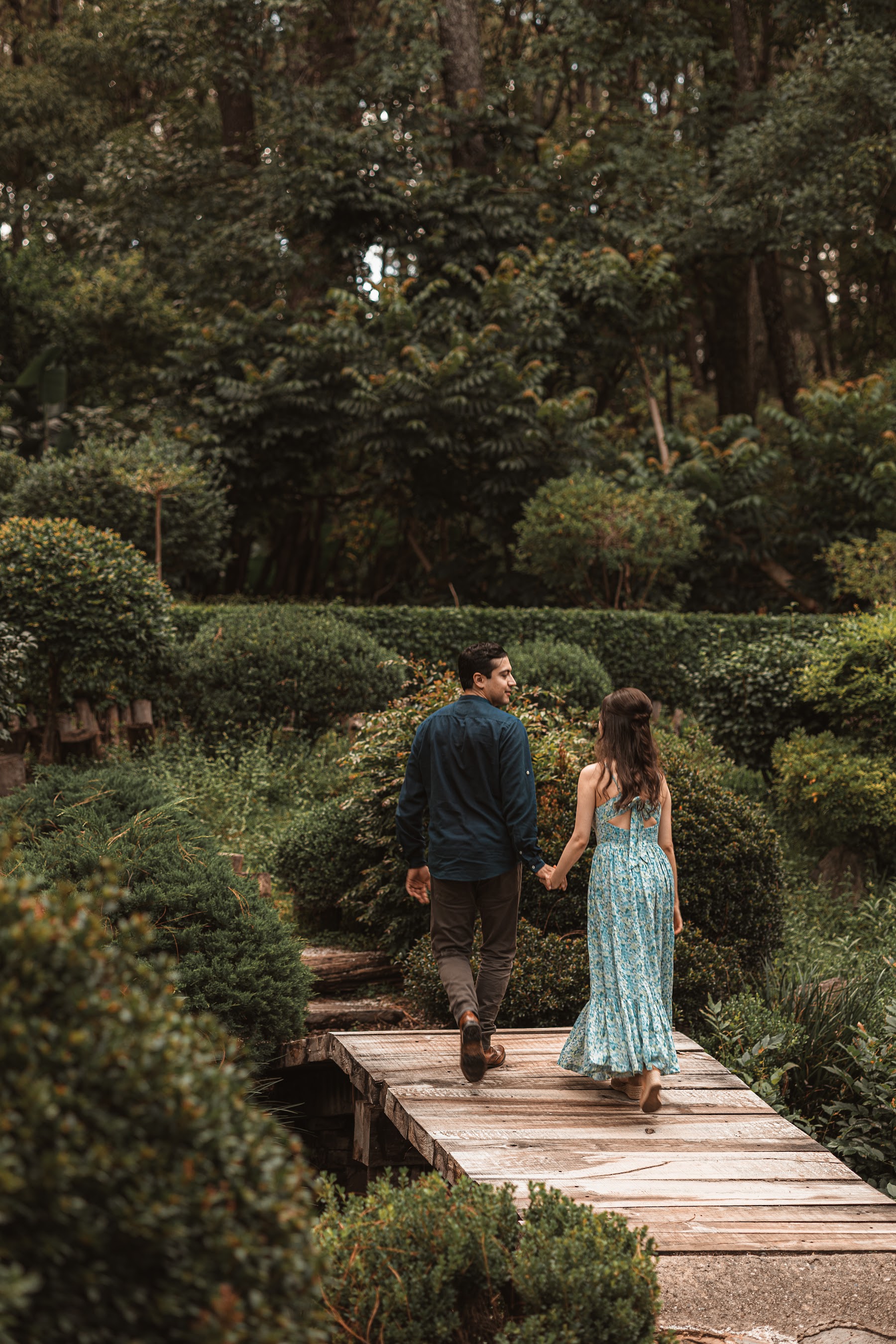 Arcelia y Adolfo avanzan por una pasarela rodeada de bosque