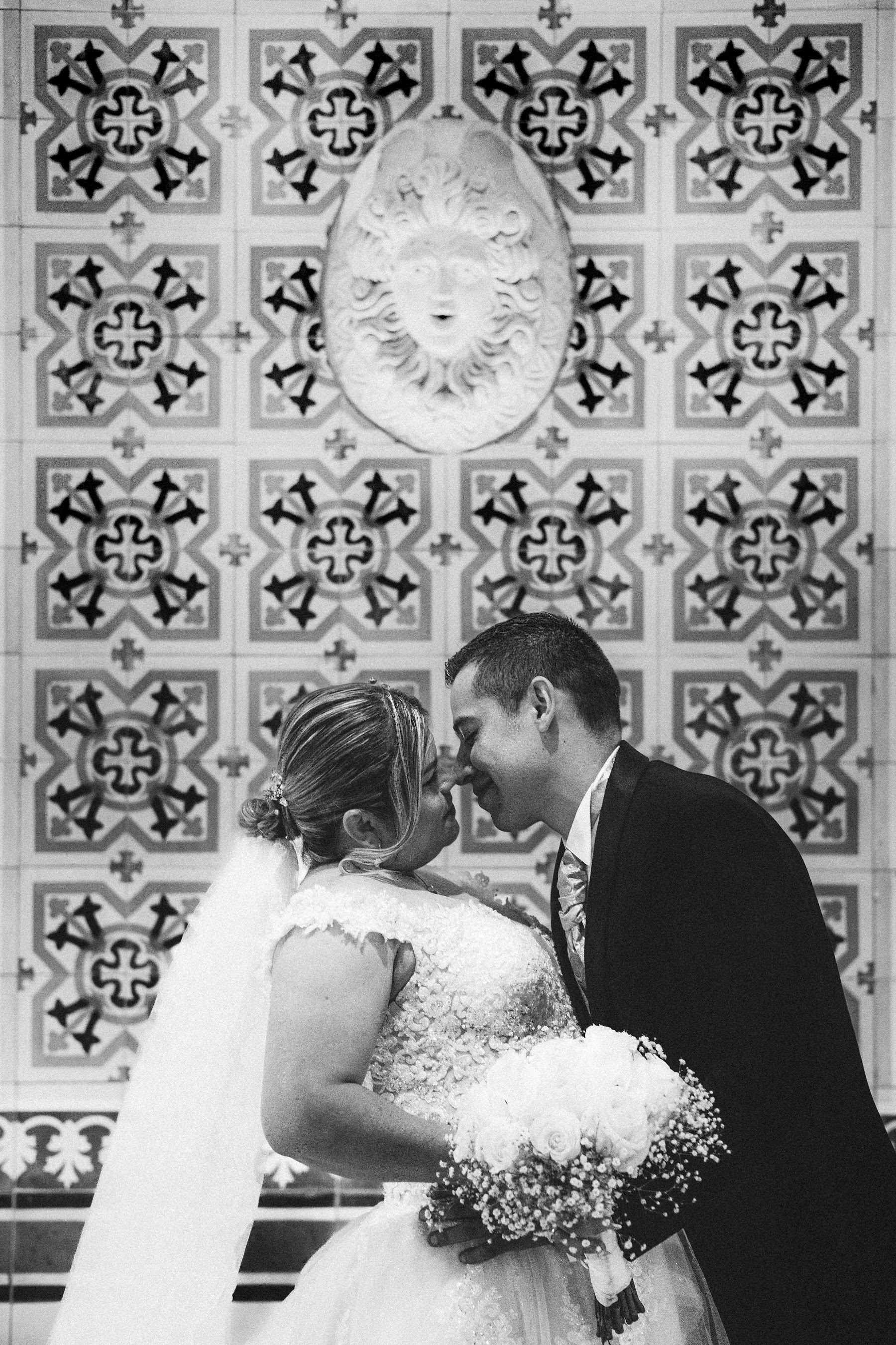 Los novios se abrazan en un retrato cercano en blanco y negro.