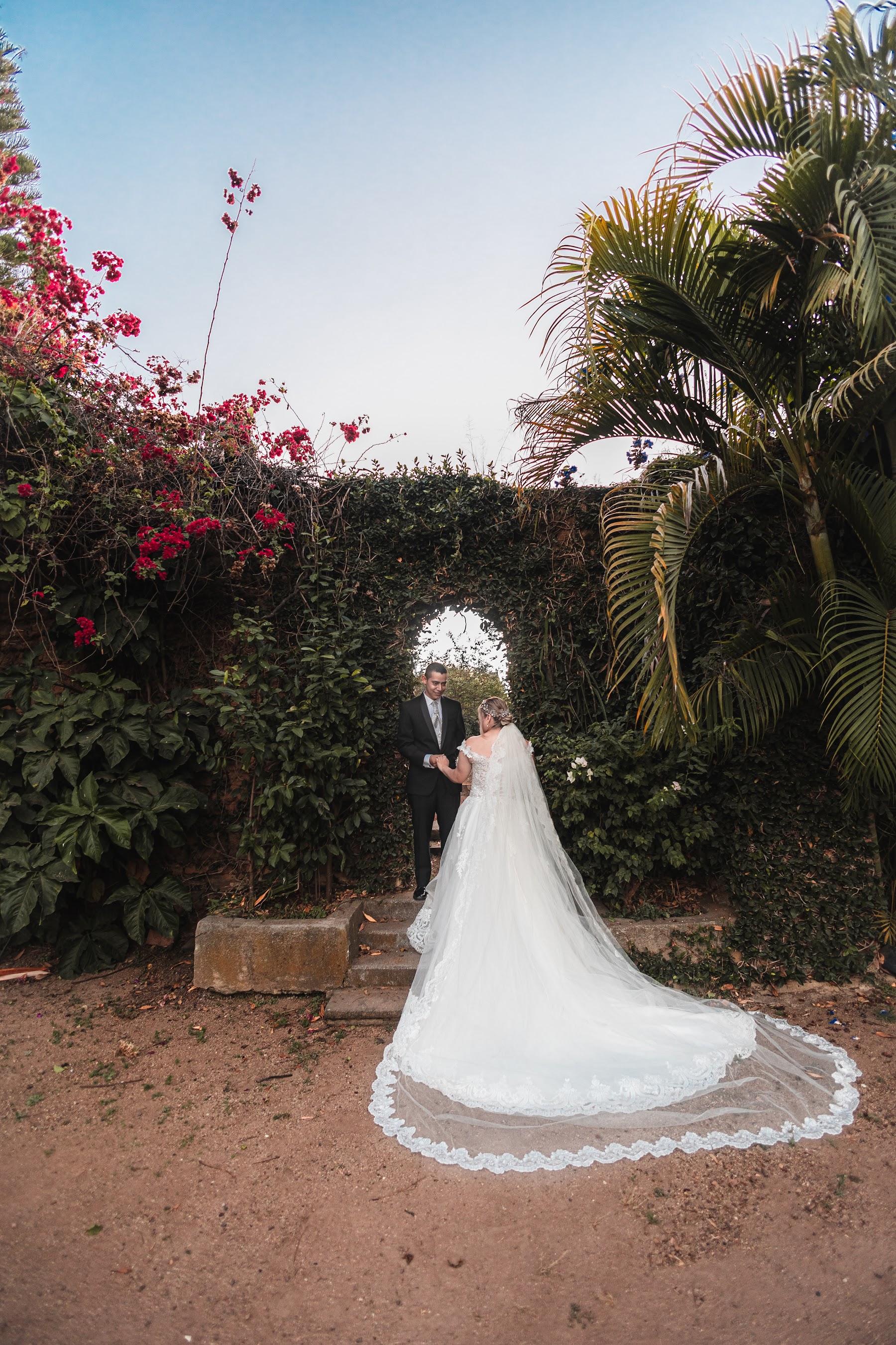 Retrato de los novios entre jardines y arquitectura de hacienda.