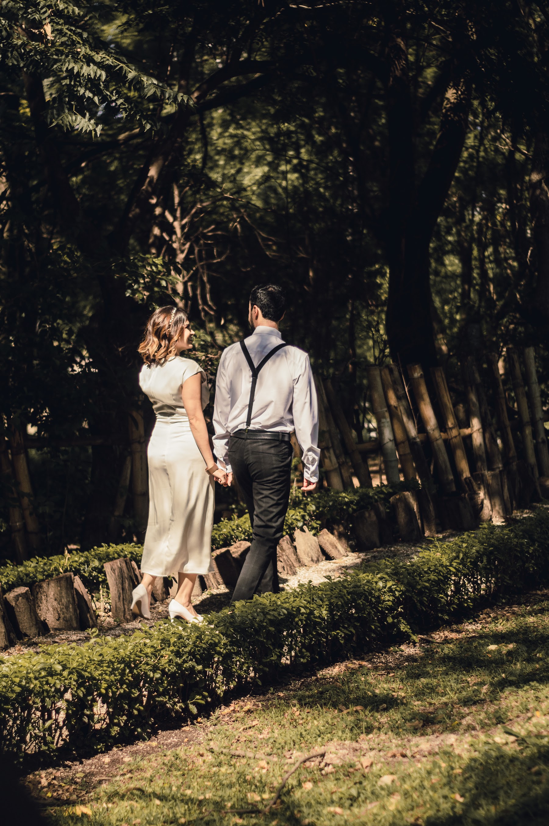 La pareja camina junta por un jardín.