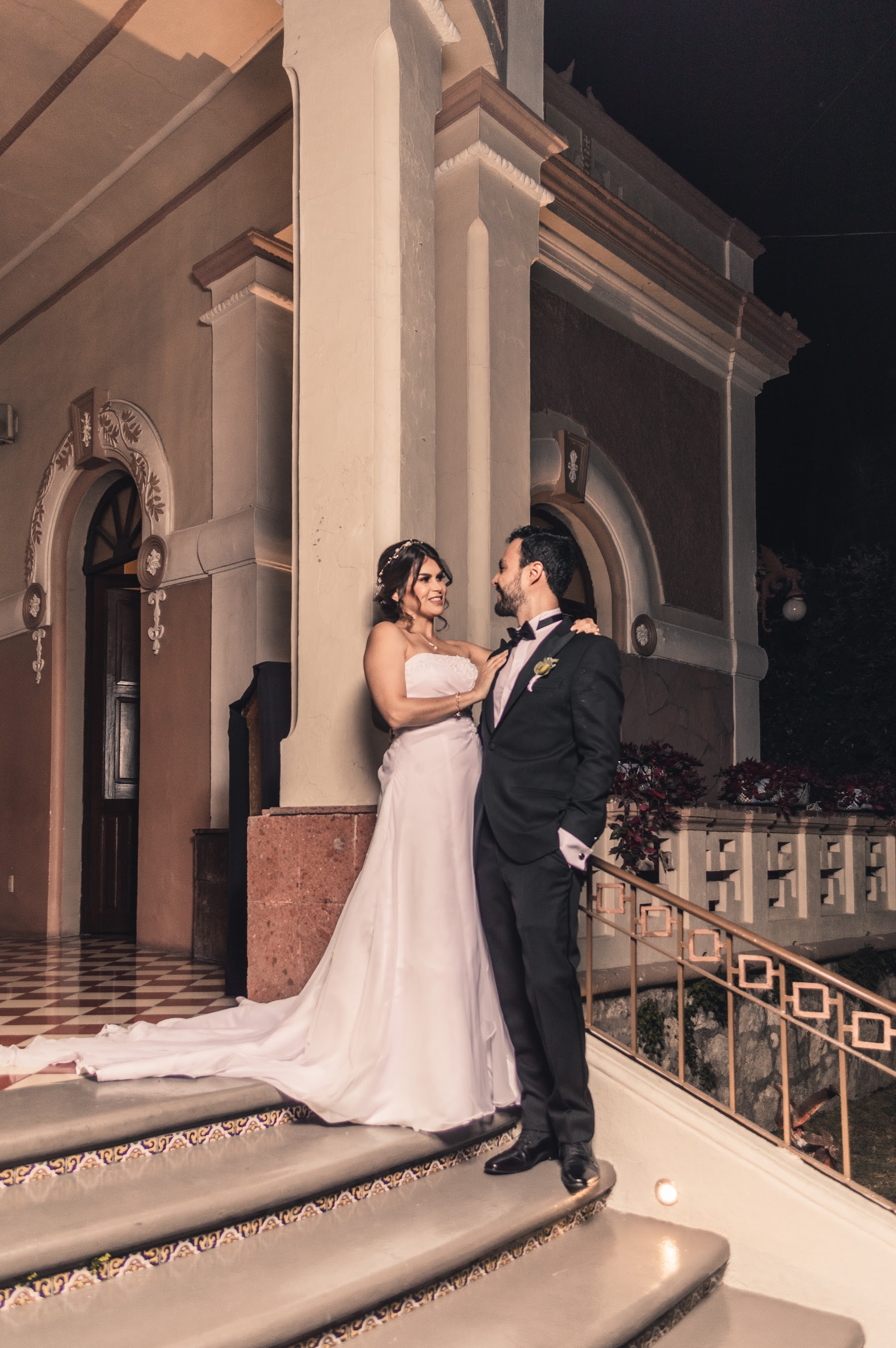 Los novios posan juntos en una escalinata.