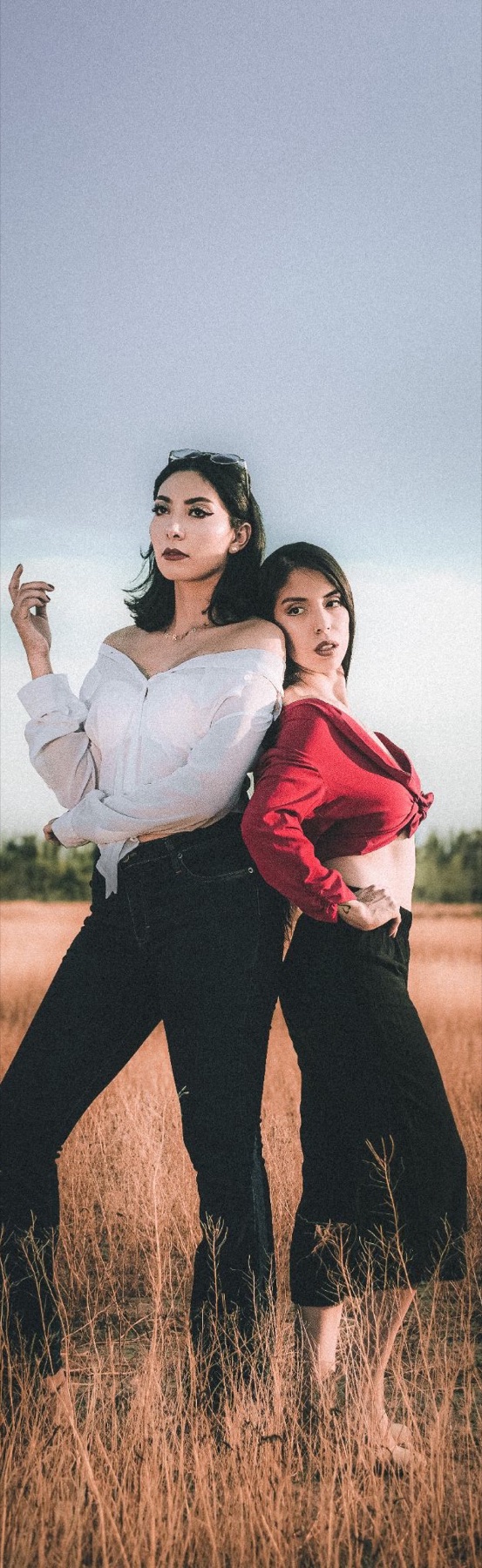 Retrato editorial de dos mujeres posando en un campo