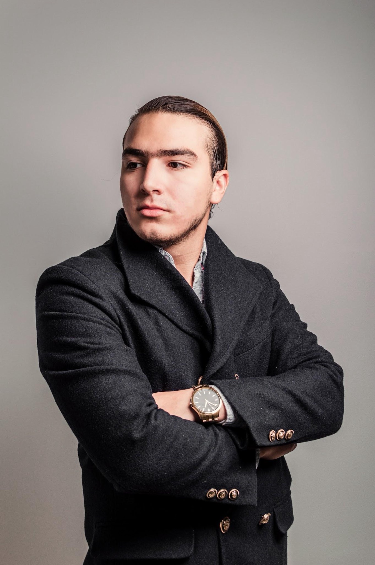 Retrato de estudio de hombre con traje negro y brazos cruzados