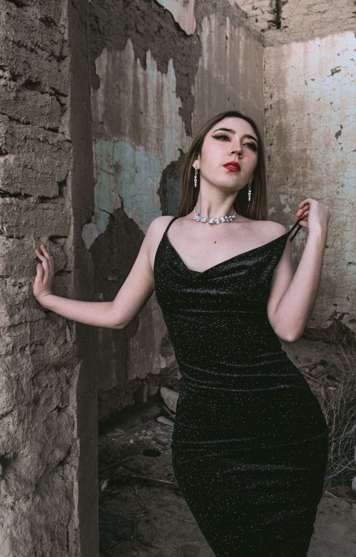 Mujer con vestido verde posando en una entrada rústica