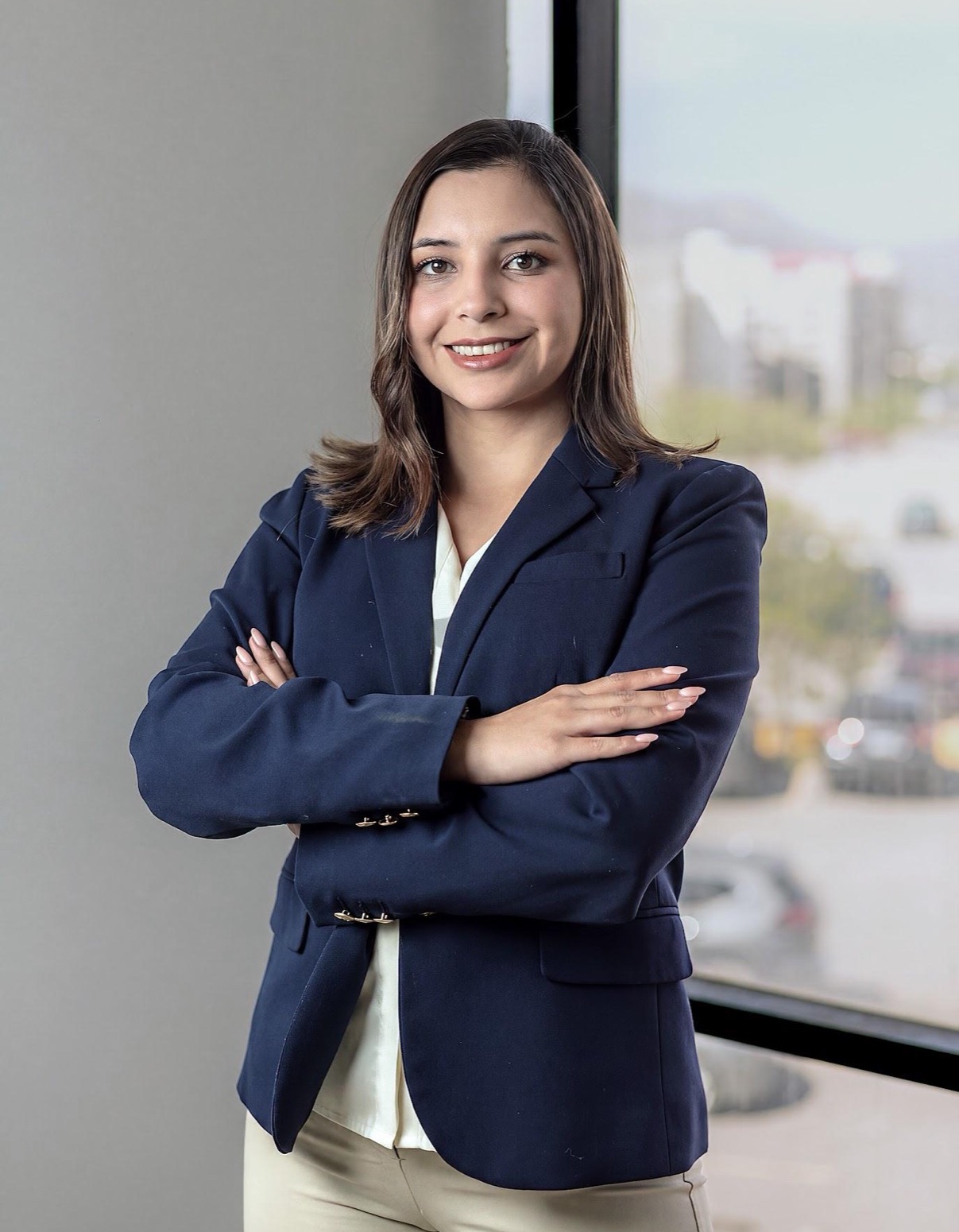 Retrato profesional de mujer con blazer azul y brazos cruzados